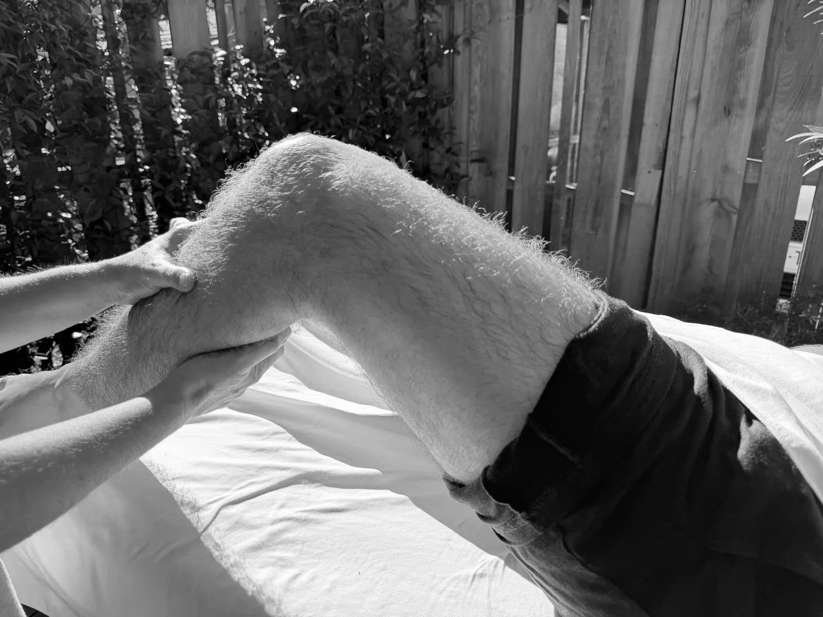 Mobilisation de la jambe pliée, mains sur le mollet et le genou – Massage sportif et récupération à Gujan-Mestras, Bassin d’Arcachon