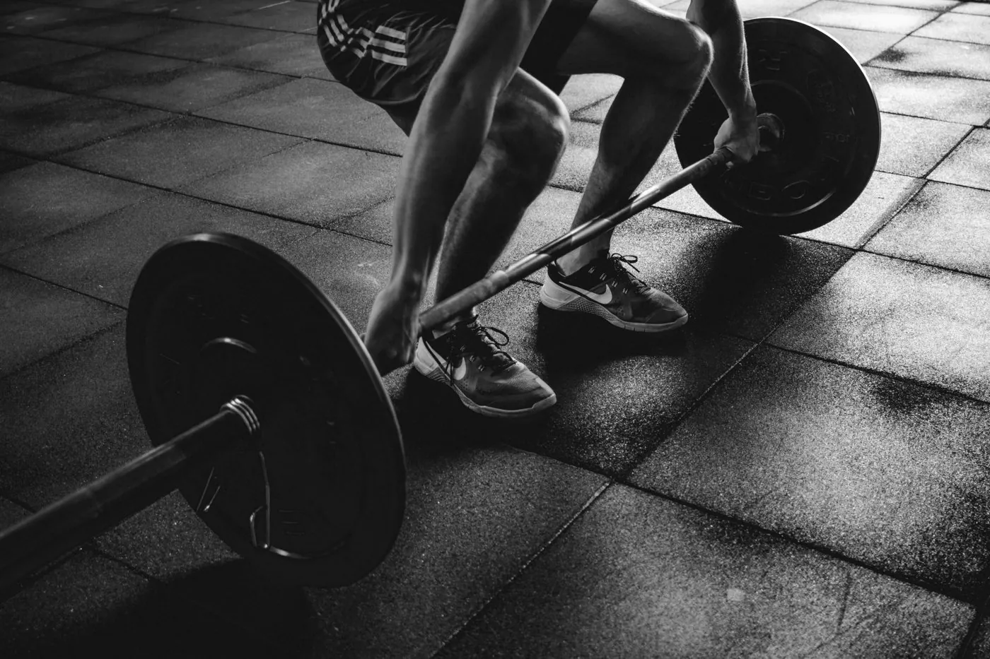 Sportif qui saisit une barre de musculation – Massage sportif et récupération à Gujan-Mestras, Bassin d’Arcachon